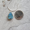 Blue Labradorite teardrop pendant necklace beside a quarter