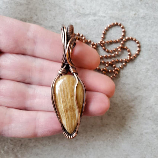 Aragonite wire wrap pendant in hand