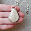 fossil coral freeform silversmith pendant in hand