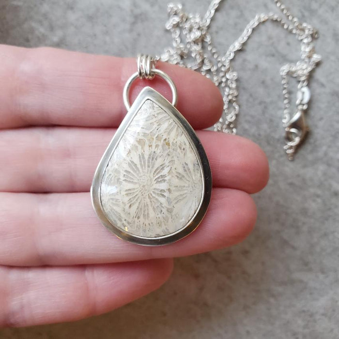 fossil coral freeform silversmith pendant in hand