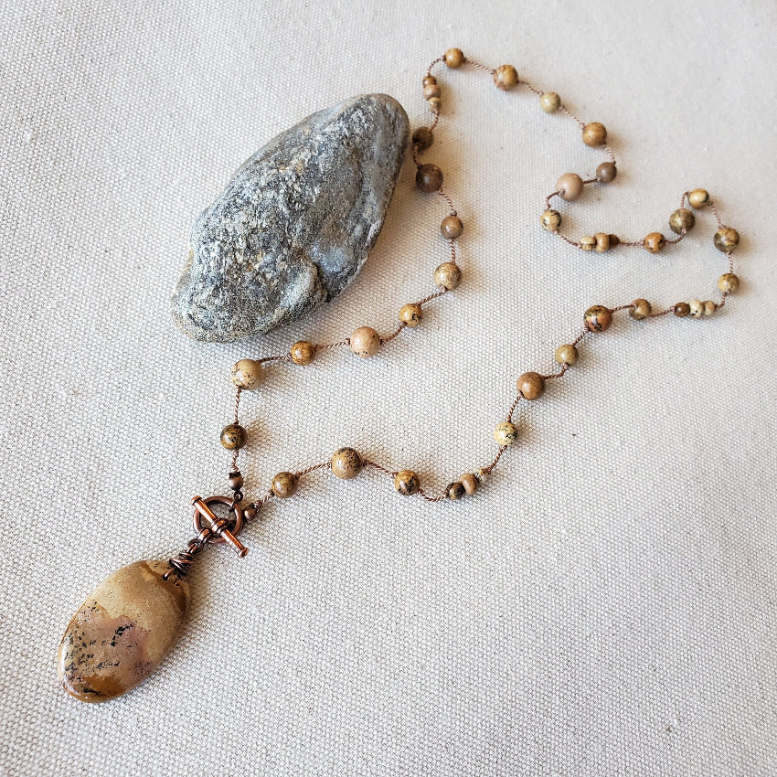 Necklace with stone pendant on a textured surface