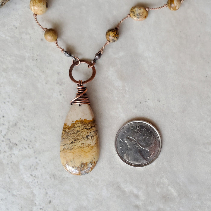 Picture Jasper knotted necklace beside a quarter