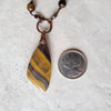 Tiger Eye long knotted necklace beside a quarter