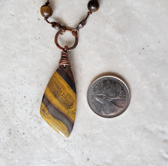 Tiger Eye long knotted necklace beside a quarter