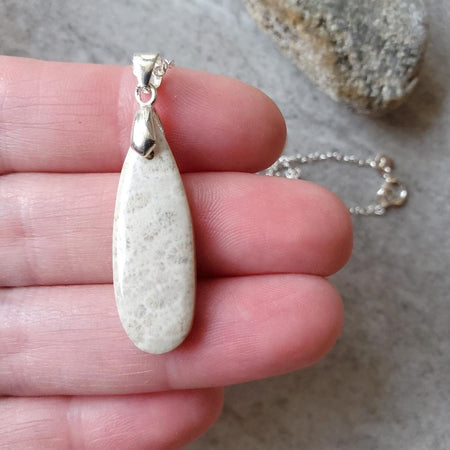 fossil coral teardrop pendant in hand