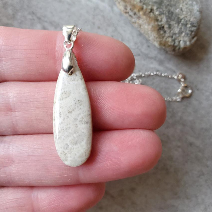 fossil coral teardrop pendant in hand