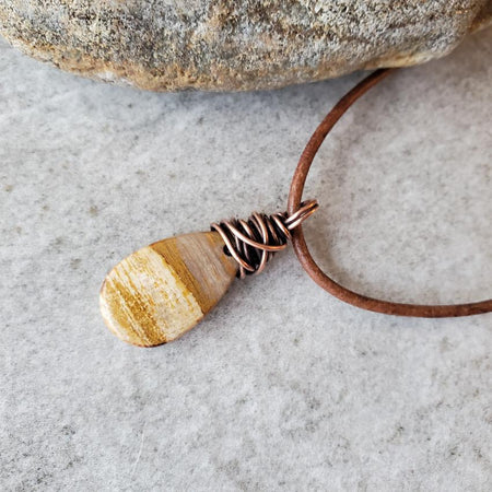 Petrified wood leather necklace on tile 