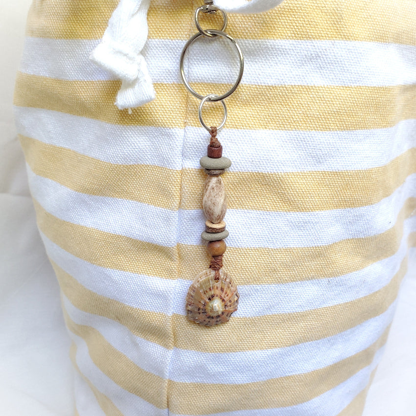 Beaded keychain with natural elements on a yellow and white striped fabric background