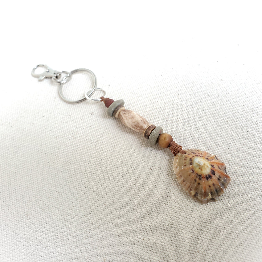 Keychain with shell and beads on a white fabric background