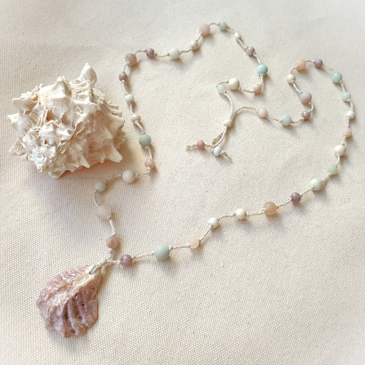 Necklace with shell pendant on a beige background