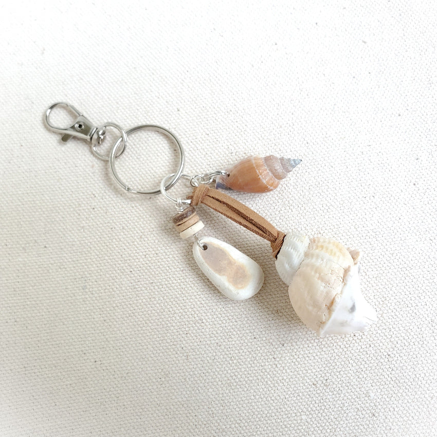 Keychain with seashells and wooden beads on a white fabric background