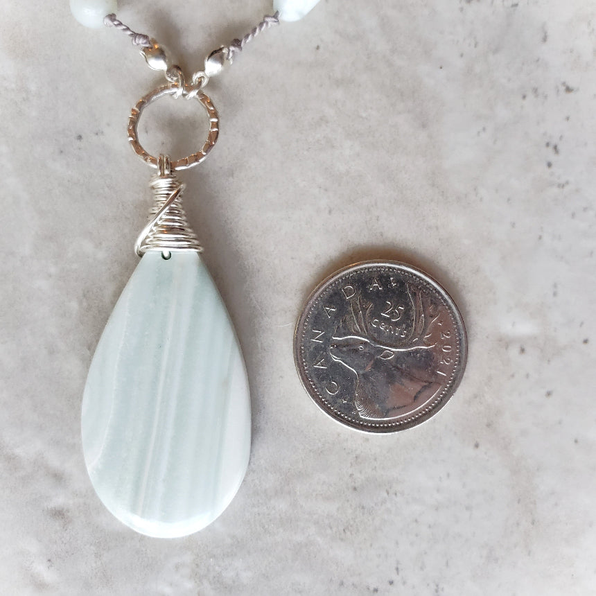 Green Lace Agate & Amazonite knotted necklace beside a quarter