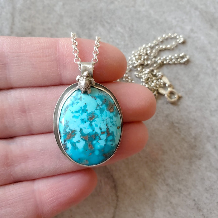 Morenci turquoise bezel set pendant in hand