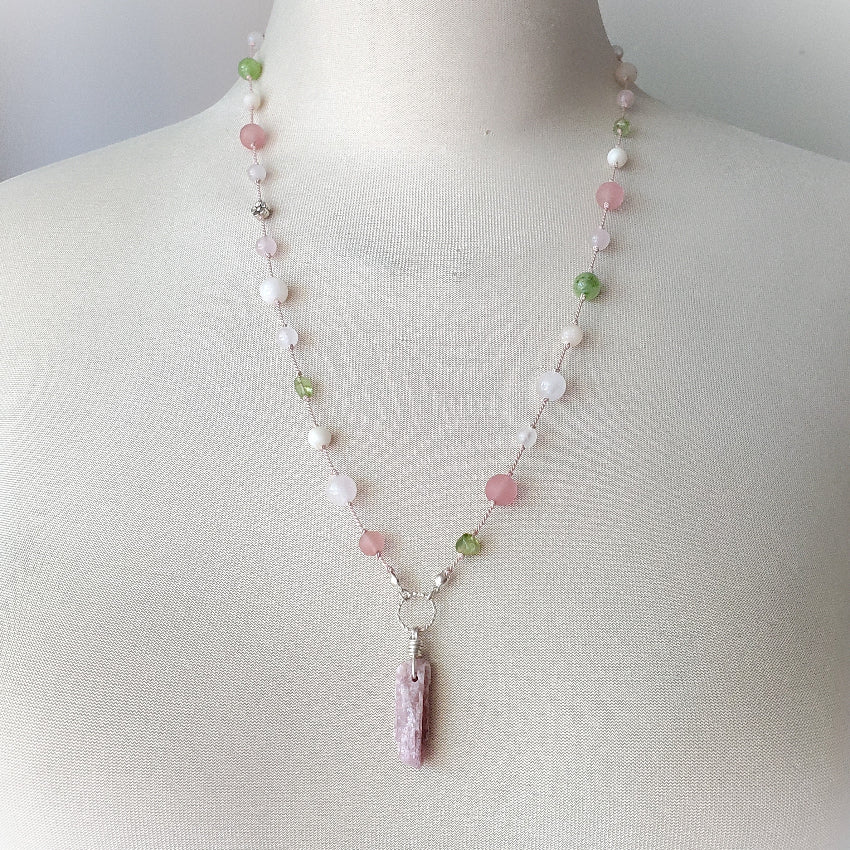 Necklace with pastel beads and a pendant on a mannequin