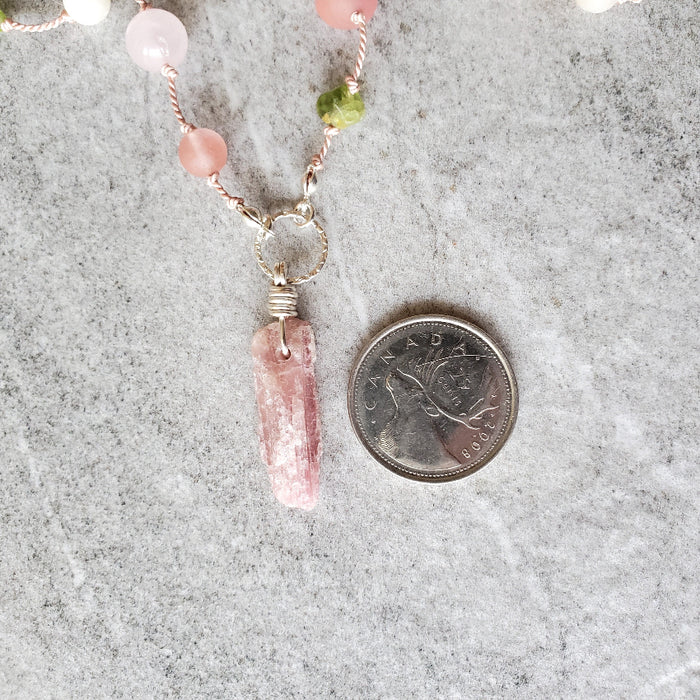 Pink Tourmaline multi gemstone knotted necklace beside a quarter