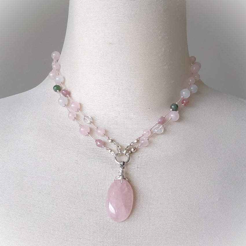 Necklace with pink pendant on a mannequin bust against a neutral background