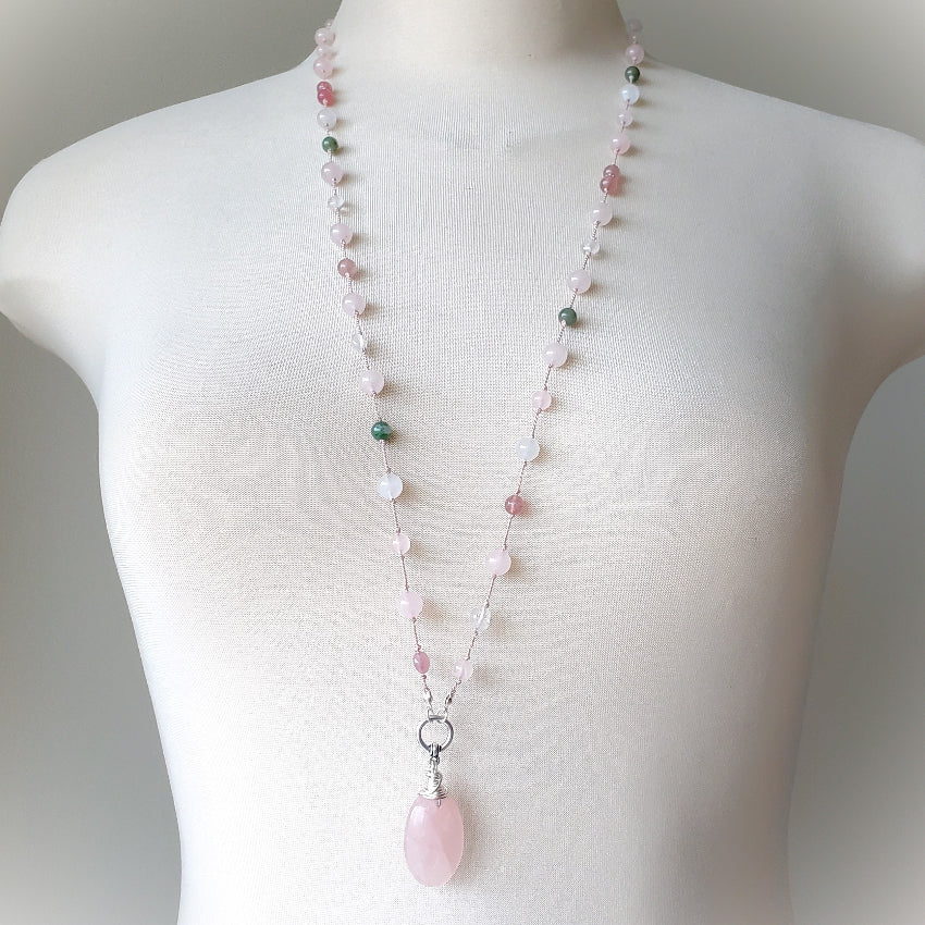 Necklace with pink pendant on a mannequin against a neutral background