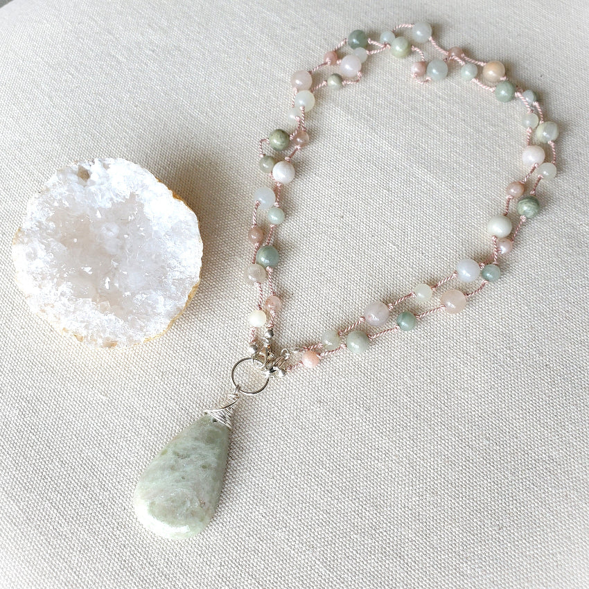 Necklace with a pendant on a light fabric background