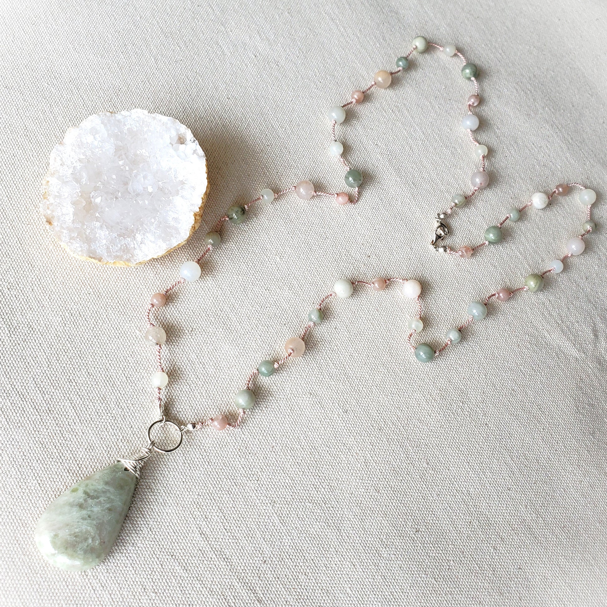Beaded necklace with a pendant on a textured surface