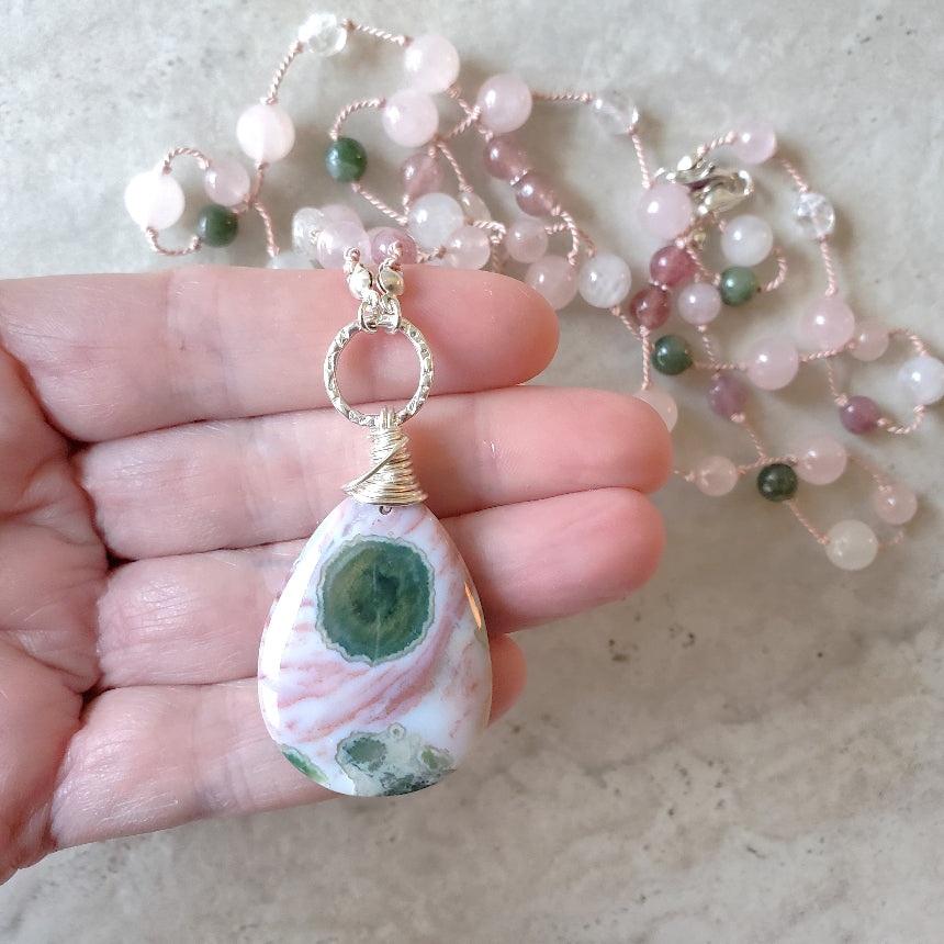 Pink and green gemstone knotted necklace in hand