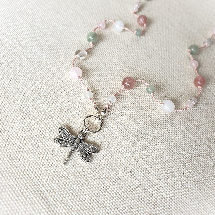 Knotted gemstone necklace with dragonfly focal on linen