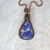Sodalite copper wire wrap pendant on tile