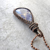 Sodalite copper wire wrap pendant on tile