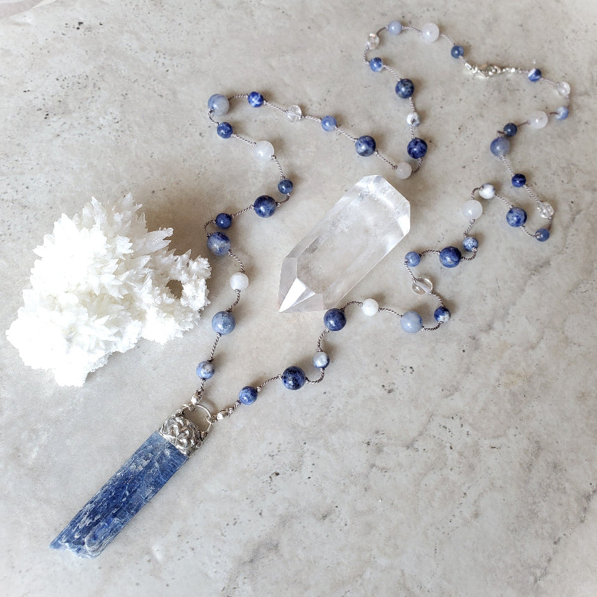 Hand knotted gemstone necklace in blue on tile