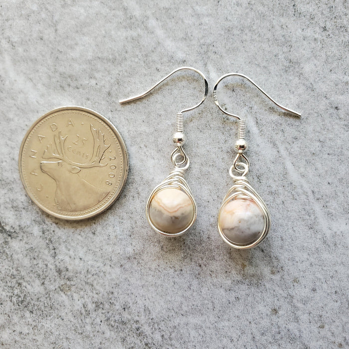 Crazy lace Agate herringbone wrap sterling silver earrings beside a quarter