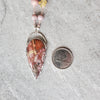 Crazy Lace Agate multi gemstone knotted necklace beside a quarter
