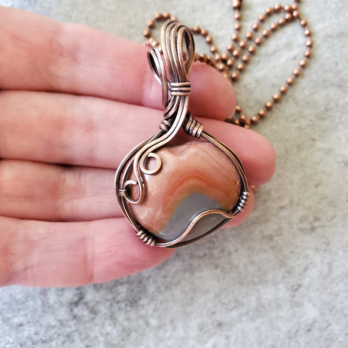Polychrome Jasper wire wrapped heart pendant in hand