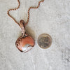 Polychrome Jasper wire wrapped heart pendant beside a quarter