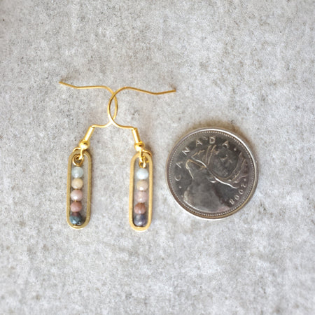 faceted Tourmaline stack earrings beside a quarter