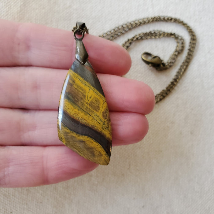 Freeform Tigers eye pendant necklace in hand