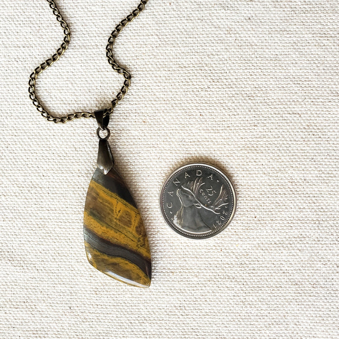 Freeform Tigers eye pendant necklace in hand