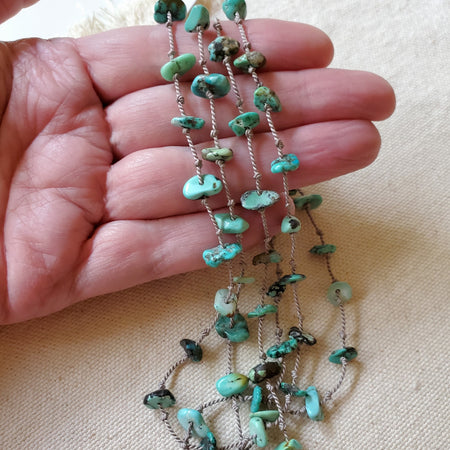Hand knotted turquoise chips on silk cord in hand