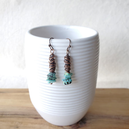 wire wrapped copper earrings with natural turquoise hanging