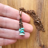 Turquoise chips copper wrap pendant in hand