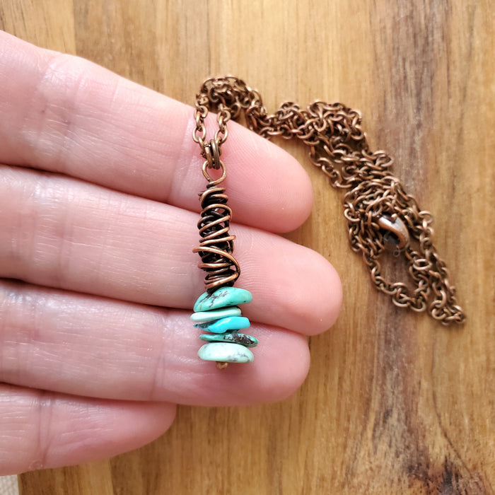 Turquoise chips copper wrap pendant in hand