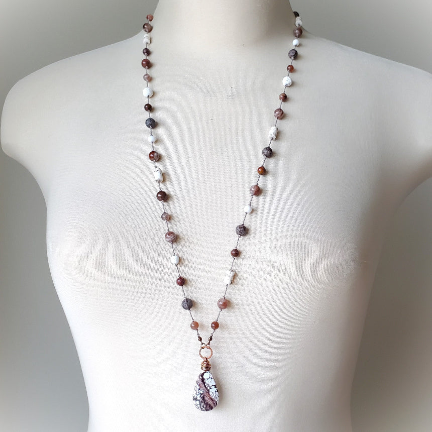 Necklace with multicolored beads on a mannequin against a neutral background