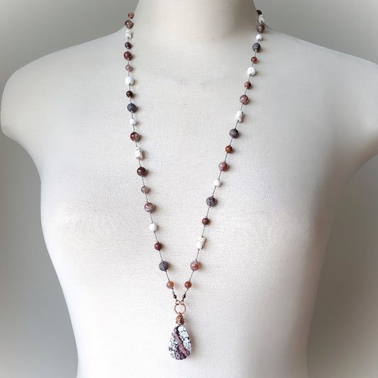 Necklace with multicolored beads on a mannequin against a neutral background