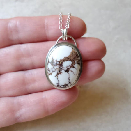 Wild Horse Magnesite oval silversmith pendant in hand