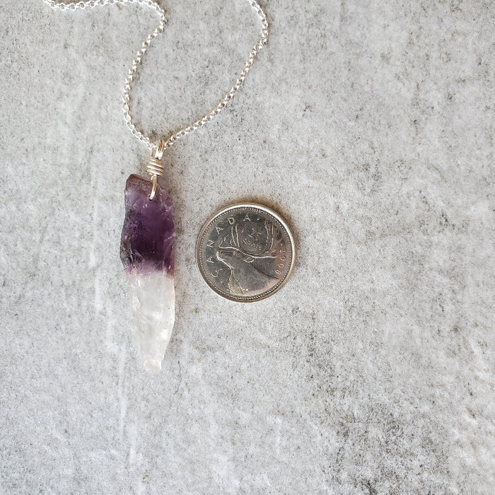 Chevron Amethyst point pendant necklace  beside a quarter