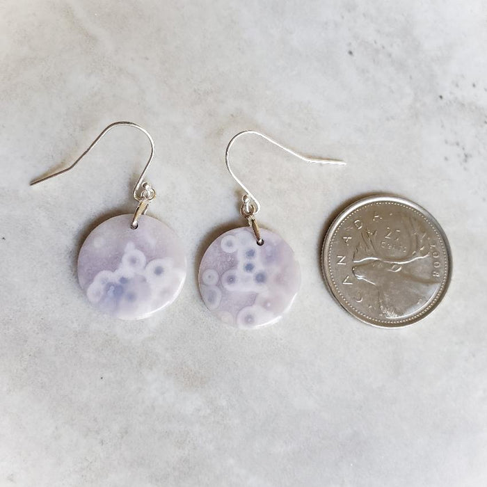 Purple Agate round earrings beside a quarter