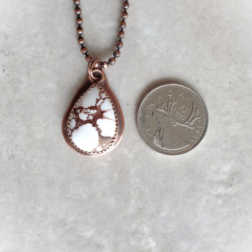 Wild Horse Magnesite teardrop pendant set in copper on tile