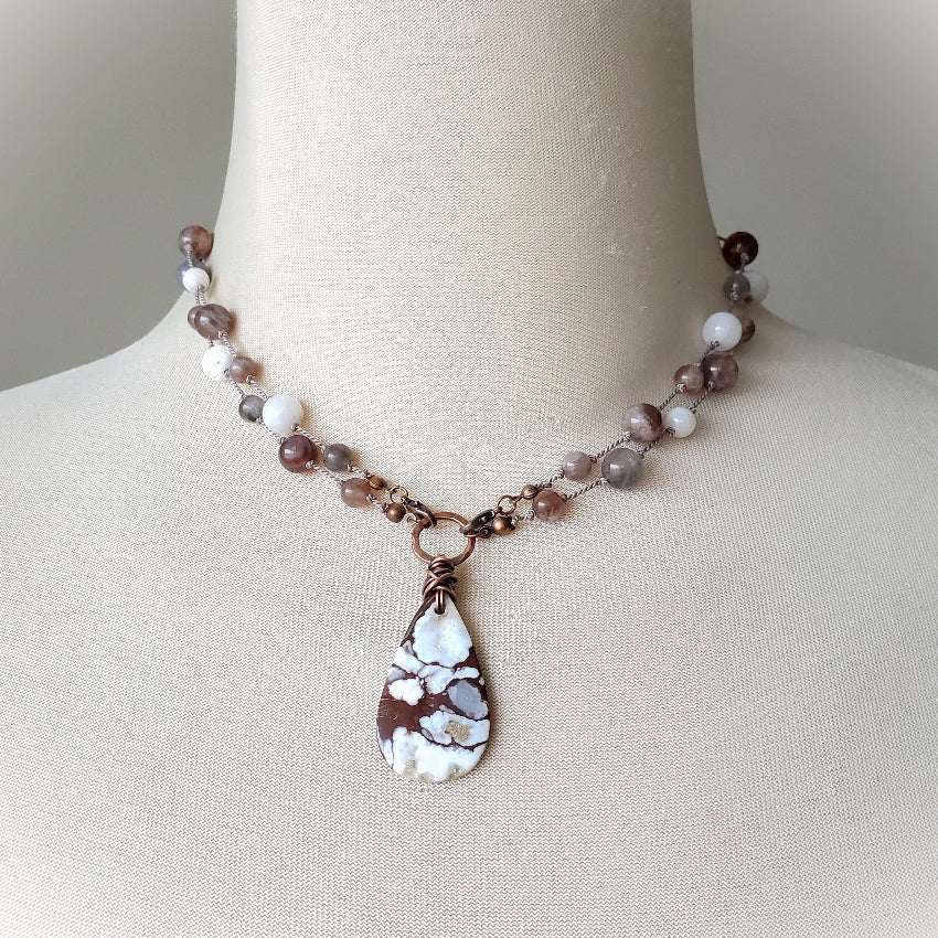 Necklace with a teardrop-shaped pendant on a mannequin bust.