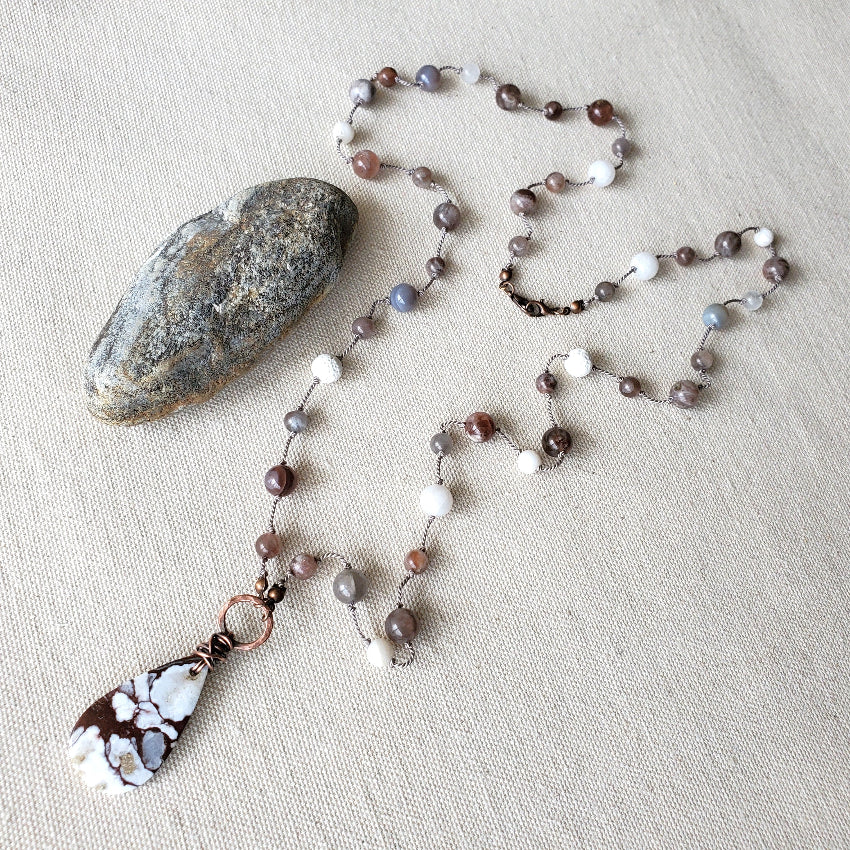 Beaded necklace with a pendant on a textured surface
