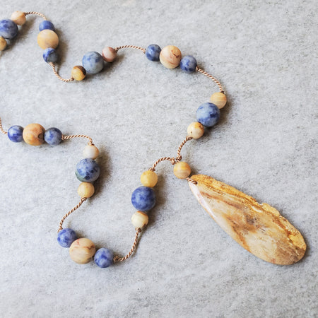 Hand Knotted gemstone Necklace in tan and blue on tile