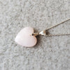 Pink Opal heart pendant hanging on a sterling silver chain