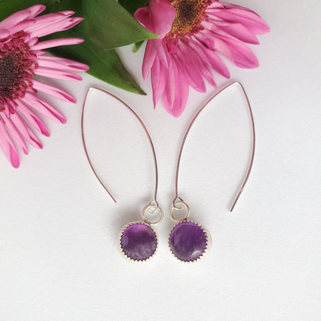Amethyst stones bezel set in sterling silver and hanging from sterling silver ear wires. 